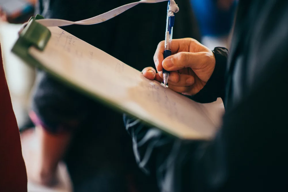 man taking inventory of office supplies on clipboard