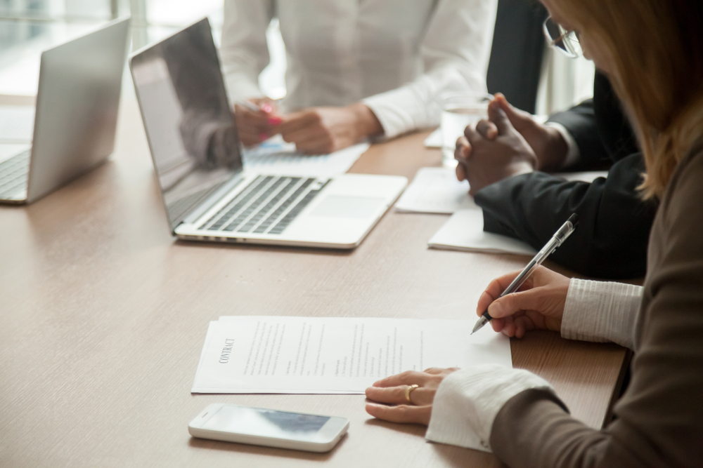 group of business people examining legal documentation at a desk